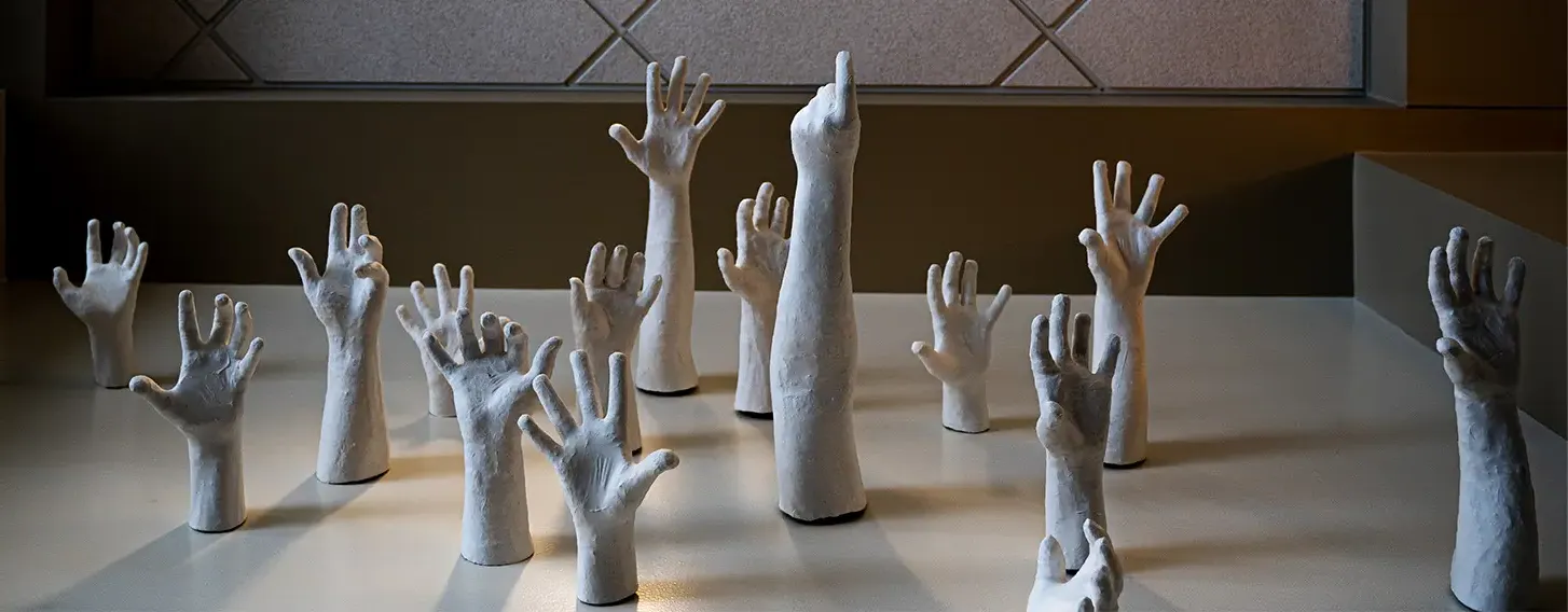 Sculptures of hands reaching up.